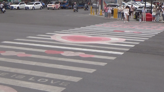 洛阳市民车流中躺坐网红“520斑马线”拍照 交警：打卡需理性