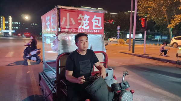 小心翼翼的搬到了贴着"小笼包"招牌的三轮车上,他骑着三轮准备到附近