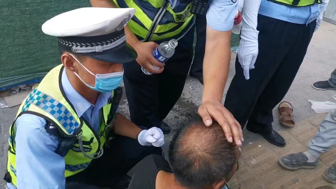 漯河一男子中暑街头晕倒交警手掌沾水敷额头为其降温