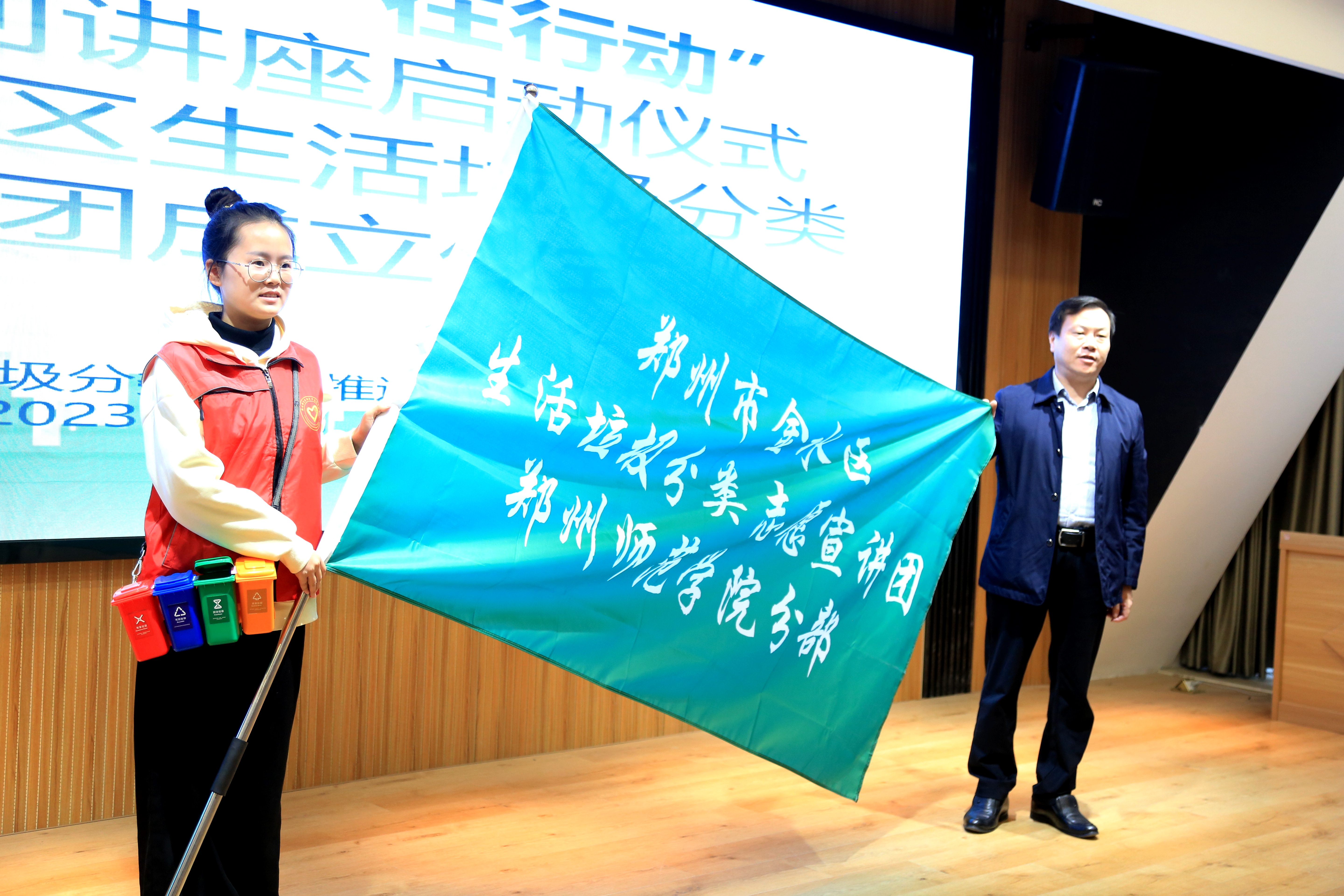 市金水区生活垃圾分类志愿宣讲团郑州师范学院分部代表王丽娜授予团旗
