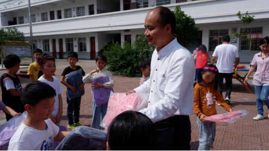 信阳市羊山中学副校长黄千里带队,为蔡店村小学全体师生捐赠乒乓球拍