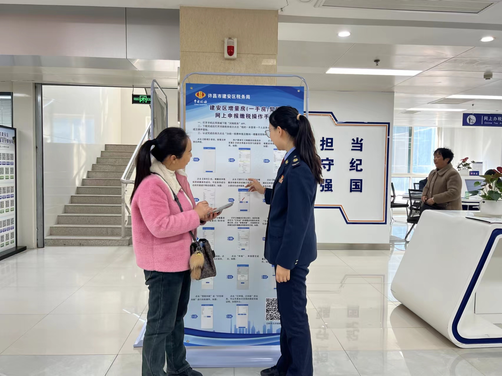 在许昌市建安区市民之家二楼的办税服务厅,市民刘女士在税务人员的