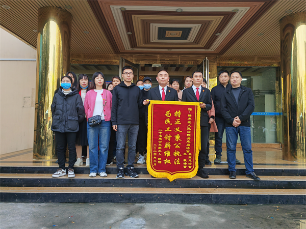 二十名申请执行人将一面印有"持正义秉公执法,为民工讨薪维权"的锦旗