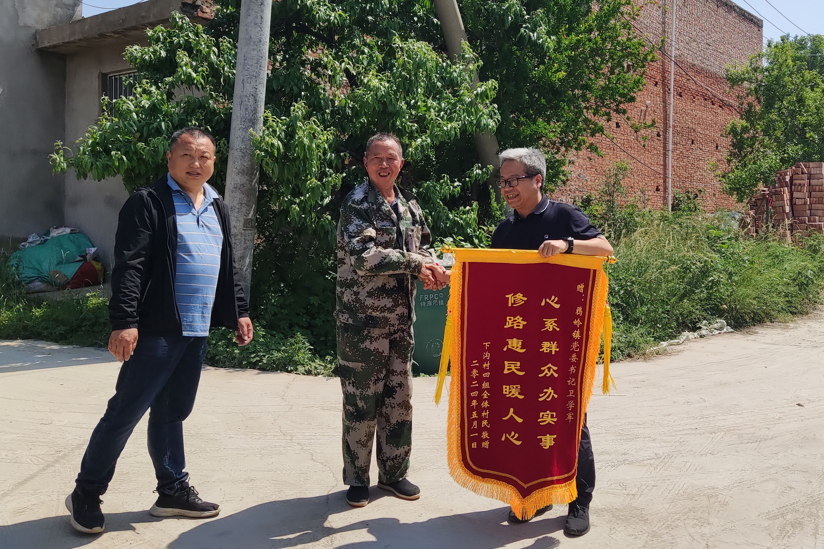 修路惠民暖人心"的锦旗送到伊川县委副书记,鸦岭镇党委书记卫学军的手