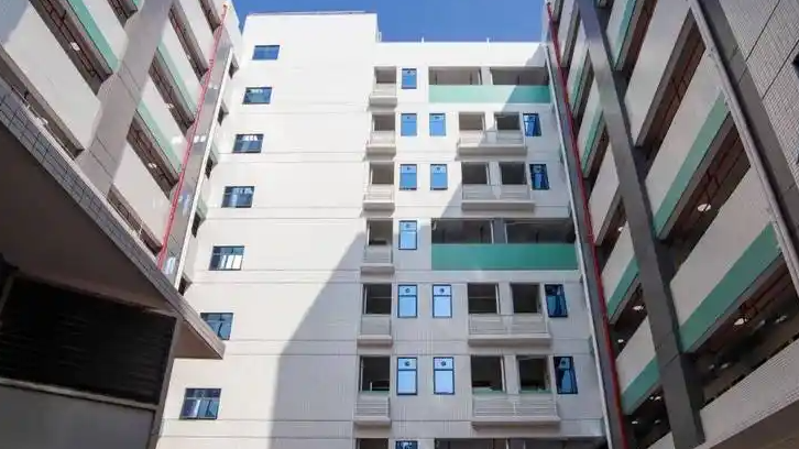 广东一家长怀抱幼儿马路边执勤，当地教体中心回应