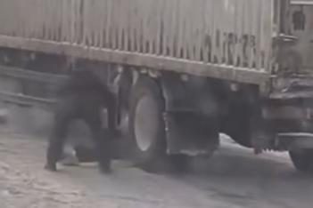 雪地里脱衣垫轮助大货车脱困的“大衣侠”，实为收费站员工