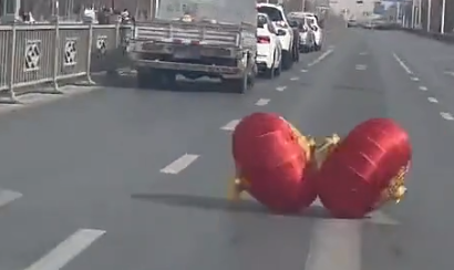 马路上一对红灯笼不断往前滚，网友：它俩怎么那么快乐