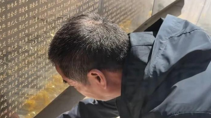 烈士家属在英名墙找到大伯名字后下跪