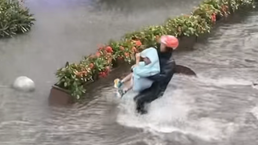 暴雨天，路人狂奔救起被水卷走的孩童