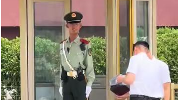 武警战士35℃高温下站岗执勤 脱下手套接过解暑饮品转身喝下