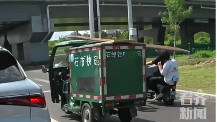 电动车主等红灯遭快递三轮车横杆“一闷棍”砸头，网友：这就是带头盔的重要性